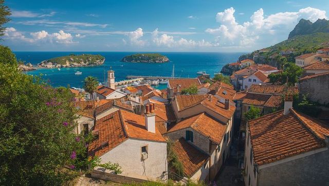 Sunlight illuminating mediterranean terracotta-roof village overlooking turquoise harbor