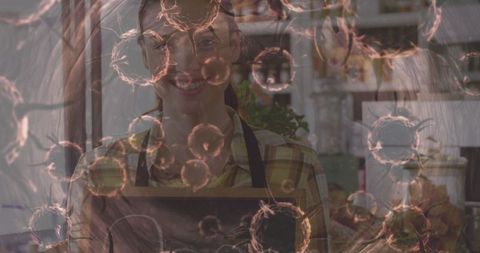 Smiling Woman in Apron with Chalkboard Surrounded by Abstract Particles