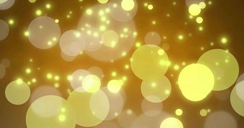 Glowing golden bokeh orbs creating warm abstract light backdrop with soft sparkles