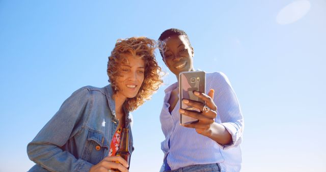 Diverse Friends Enjoying Sunny Day Together, Smiling at Smartphone - Download Free Stock Images Pikwizard.com