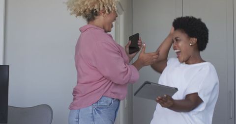 Joyful Friends Sharing Laughter with Tablet Technology