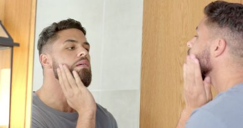 Man Grooming Beard in Minimalist Bathroom Mirror Reflection