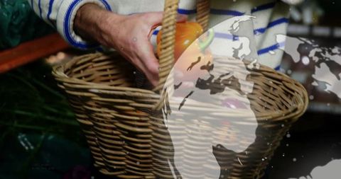 Man filling wicker basket with colorful easter eggs, world map overlay