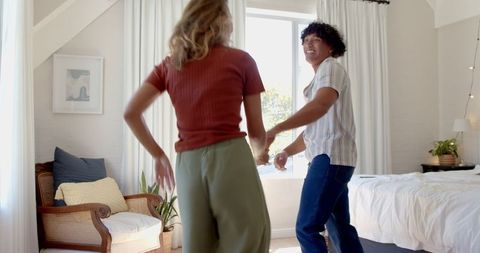 Joyful Couple Dancing Together in Sunlit Bedroom