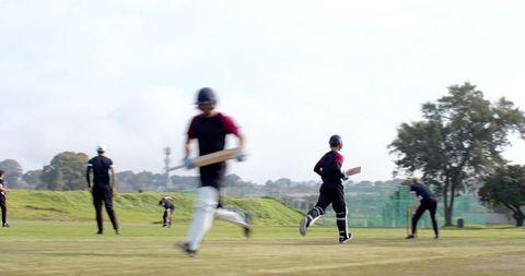 Cricketers Running Between Wickets on Outdoor Pitch