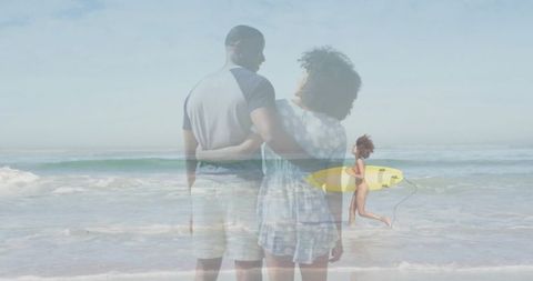 Couple Embracing on Beach with Surfer Running Underneath