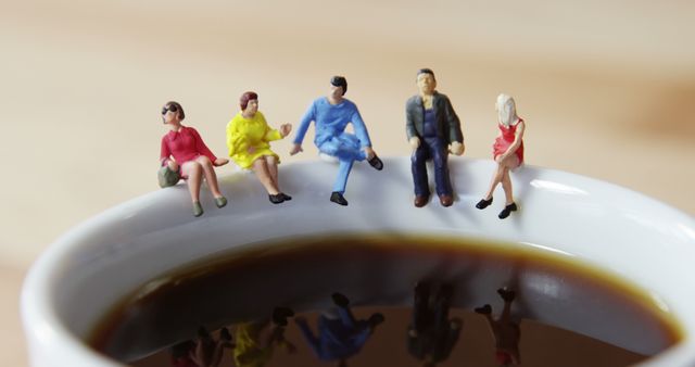 Miniature people figurines sitting on coffee cup rim - Download Free Stock Images Pikwizard.com