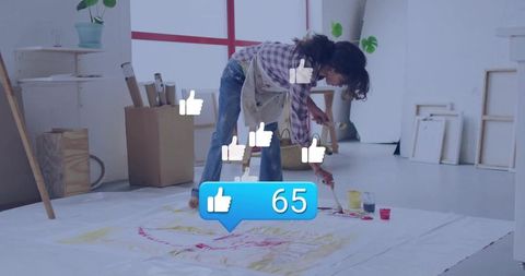 Artist engaging in painting with social media like icons overlay