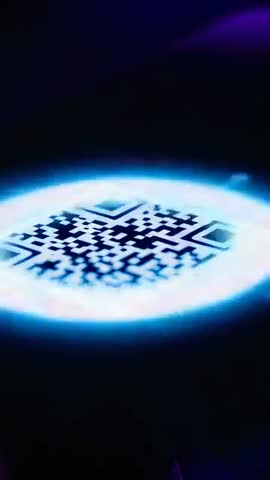 Vertical neon QR code scanning with pulsing cyan access verification on holographic pad