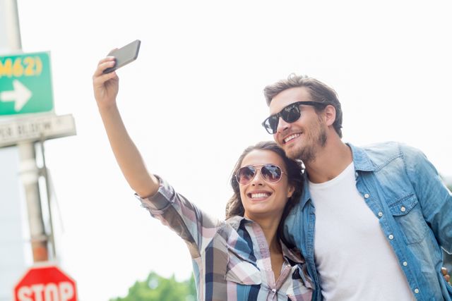 Young couple in sunglasses taking a selfie on a mobile phone