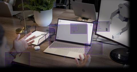 Man gesturing at laptop with ar screen annotations on modern workspace desk