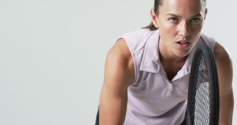 Determined Female Tennis Player in Action on White Background