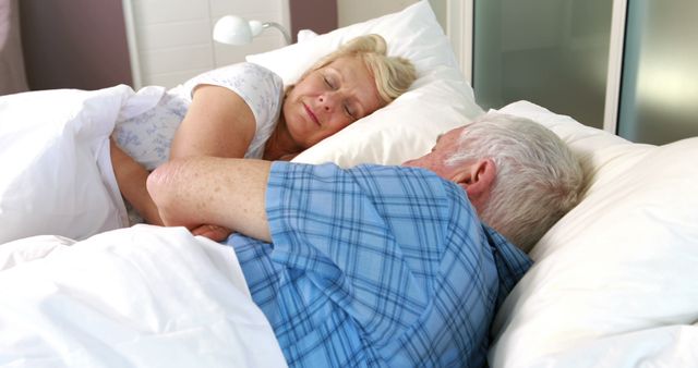 Senior couple sleeping in bed together