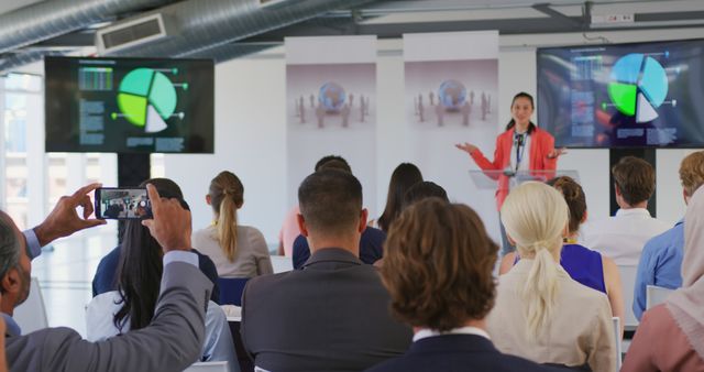 A man films a presentation at a business conference with a diverse audience in attendance. - Download Free Stock Photos Pikwizard.com