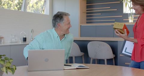 Senior couple celebrating achievement at home with certificate