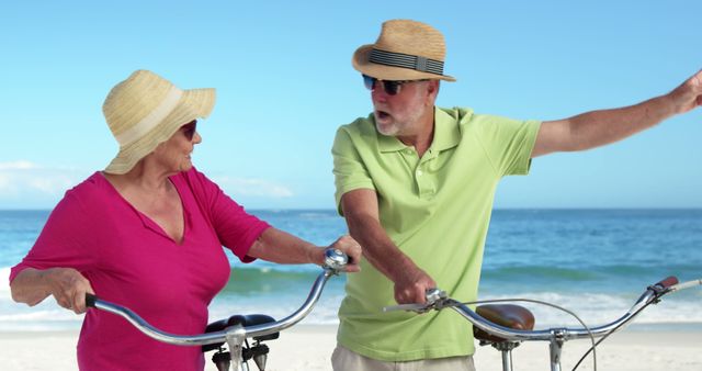 Senior couple riding bicycles on beach, enjoying active lifestyle and recreation time. Can use for retirement, health, and wellness promotions, or travel advertisements targeted at older adults. Highlights happiness, companionship, and outdoor leisure.