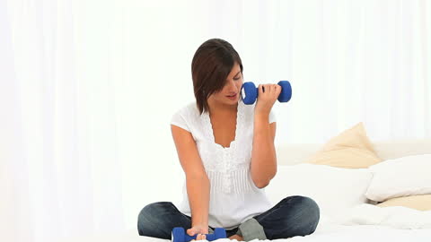 Casual Woman Exercising With Dumbbells At Home
