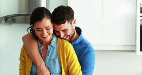 Happy Couple Embracing in Kitchen Enjoying Cozy Home Cooking