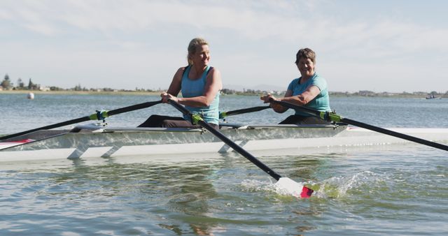 Two Women Rowing in Synch on Calm Lake on a Sunny Day - Download Free Stock Images Pikwizard.com