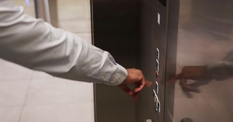 Person pressing button on modern elevator control panel