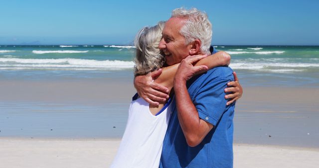 Senior couple hugging on beach with ocean waves in background - Download Free Stock Images Pikwizard.com
