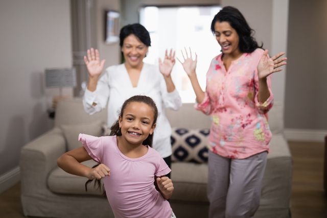 Three generations of women enjoying a fun moment together in their living room. Perfect for promoting family values, home life, and joyful moments. Ideal for use in advertisements, social media posts, and family-oriented content.