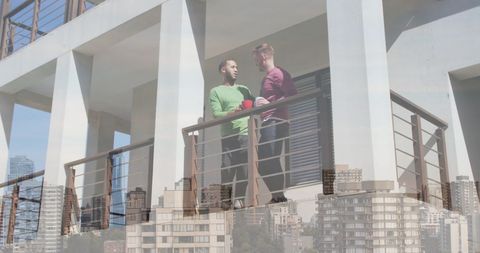 Diverse Couple Enjoying Coffee on Balcony with Urban Cityscape - Download Free Stock Images Pikwizard.com
