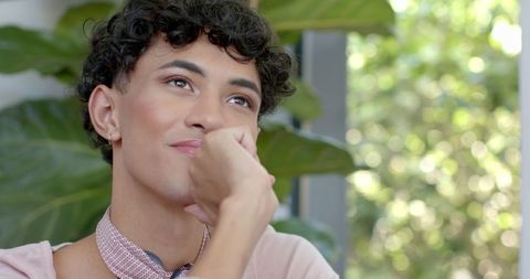 Thoughtful Young Man with Curl Hairstyle in Relaxed Interior Setting