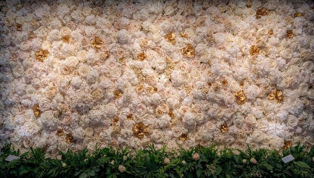 Luxurious cream rose and peony floral wall backdrop with gold accents and lush greenery