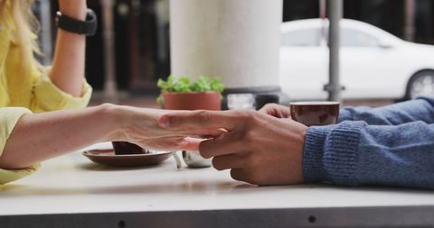 Romantic Couple Sitting at Café Holding Hands Outdoors