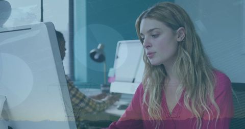 Businesswoman Analyzing Data on Computer with Financial Overlay