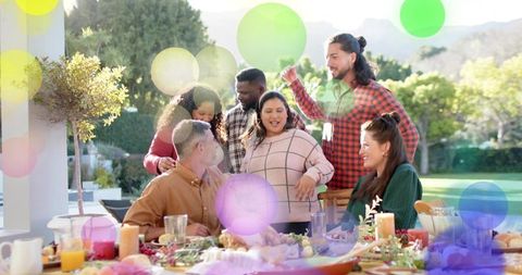 Group gathering for outdoor holiday dinner on sunny patio sharing roast bird and laughter