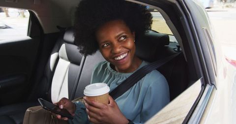 Smiling Businesswoman in Car Holding Coffee and Smartphone - Download Free Stock Images Pikwizard.com