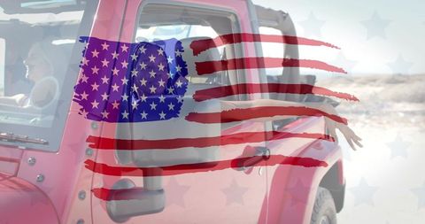 Red jeep cruising sandy shore with friends waving and painted american flag overlay