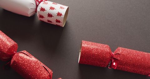 Red and white christmas crackers on grey background