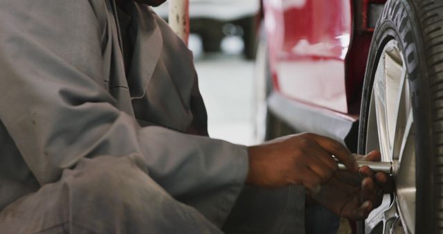 Mechanic Fixing Car Tire in Auto Repair Shop - Download Free Stock Images Pikwizard.com