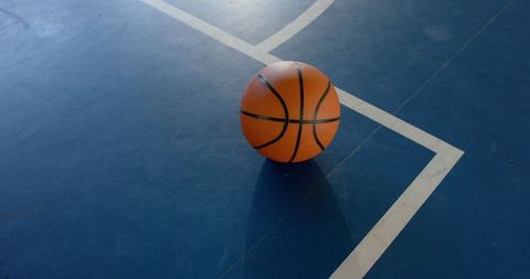 Basketball on Blue Court with Shadow and White Lines