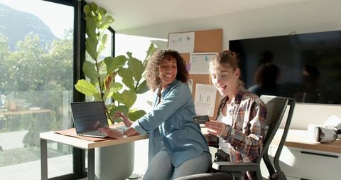Diverse coworkers collaborating on online payment at modern office