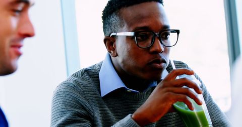 Young professional enjoying smoothie during work break