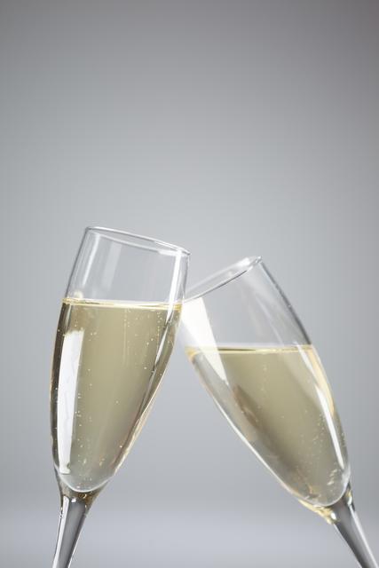 Close-up of two champagne flutes on white background