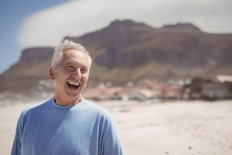 Joyful Senior Man Laughing at Scenic Beachfront Location