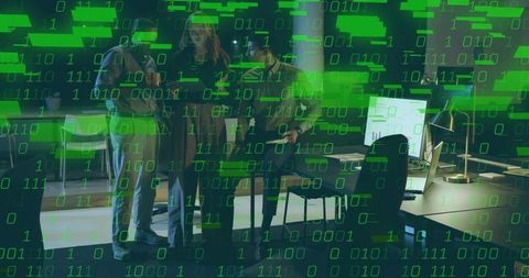 Coworkers Reviewing Cybersecurity Data on Office Monitors with Binary Overlay