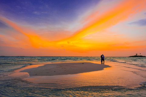 Couple Embracing on Serene Beach at Sunset