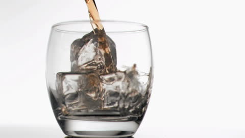 Smooth Whiskey Pouring into Glass with Ice