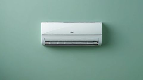Wall-mounted air conditioner on mint green wall in minimalist interior