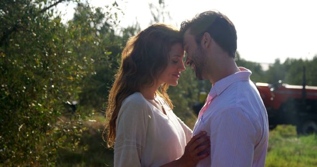 A Caucasian couple shares a tender moment in a sunlit outdoor setting, with copy space - Download Free Stock Photos Pikwizard.com