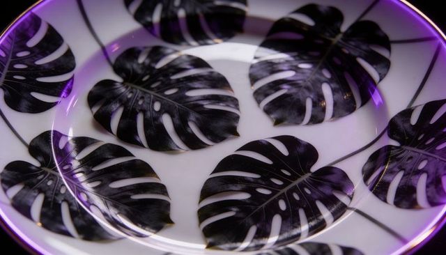 Monstera leaf porcelain plate with glossy black print and purple rim glow