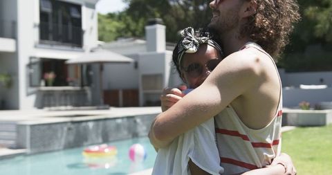 Diverse Couple Embracing By Pool on Sunny Day