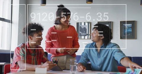 Multicultural team collaborating around tablet with data analytics overlay in modern office