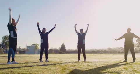 Women Doing Team Stretching Exercises at Sunrise